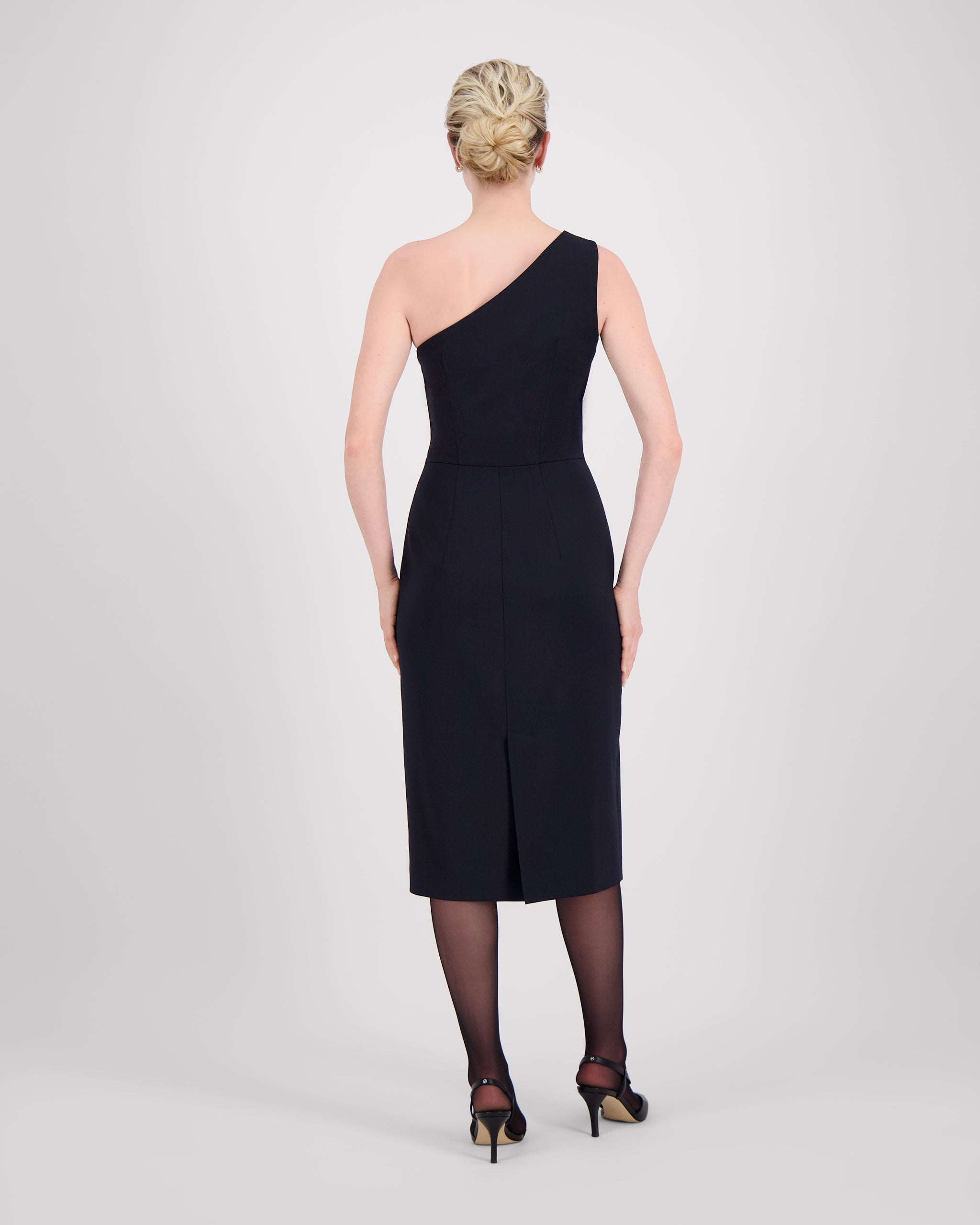 Asymmetrisches Kleid mit einer Schulter und feinen Falten für eine elegante Drapierung. Figurbetonte Silhouette mit präzisen Abnähern, knielangem Schnitt und rückwärtigem Gehschlitz. Unsichtbarer Reissverschluss an der Seite und feiner Blindsaum für ein modernes, minimalistisches Design.