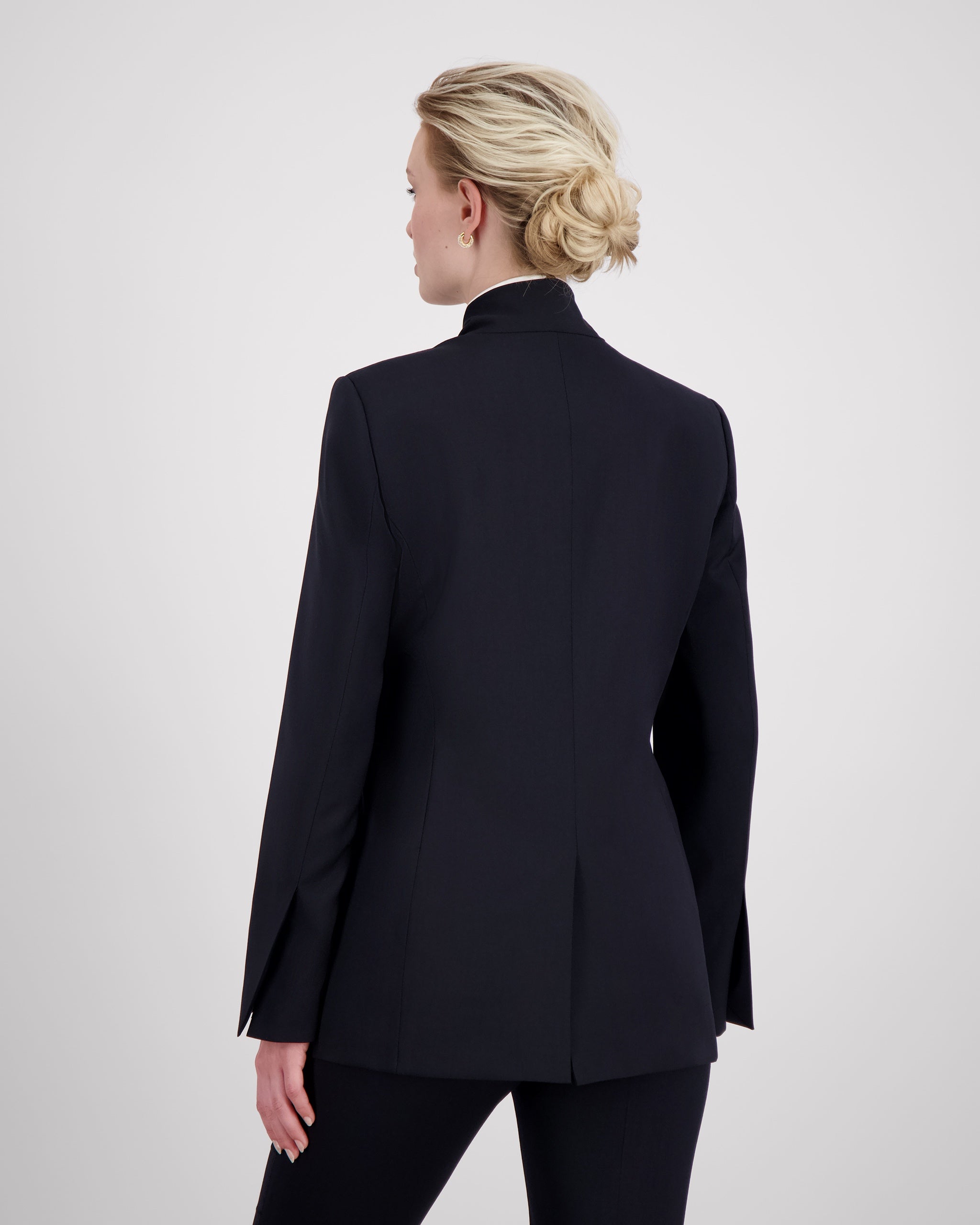 Blazer mit nach vorne versetzter Seitennaht und formgebenden Passformnähten für eine schlanke, konturierte Silhouette. Schulterpolster verleihen klare Struktur, zweiteilige Ärmel sorgen für präzisen Sitz. Dezente Details wie Ärmelschlitz, Corozo-Knopf, Rückenschlitz und schmale Pattentasche unterstreichen das reduzierte, fliessende Design.