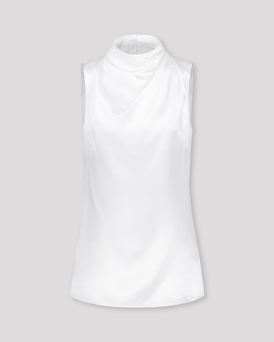 Asymmetrisch geschnittenes Top mit sanft drapierter Schulter für eine feminine, schwungvolle Silhouette. Der hochgeschlossene Stehkragen wird im Rückenteil durch einen feinen Schlitz und drei goldene Knöpfe mit filigranen Knopfschlingen akzentuiert. Ein edles Detail, das das puristische Design um eine subtile Note von Noblesse ergänzt.