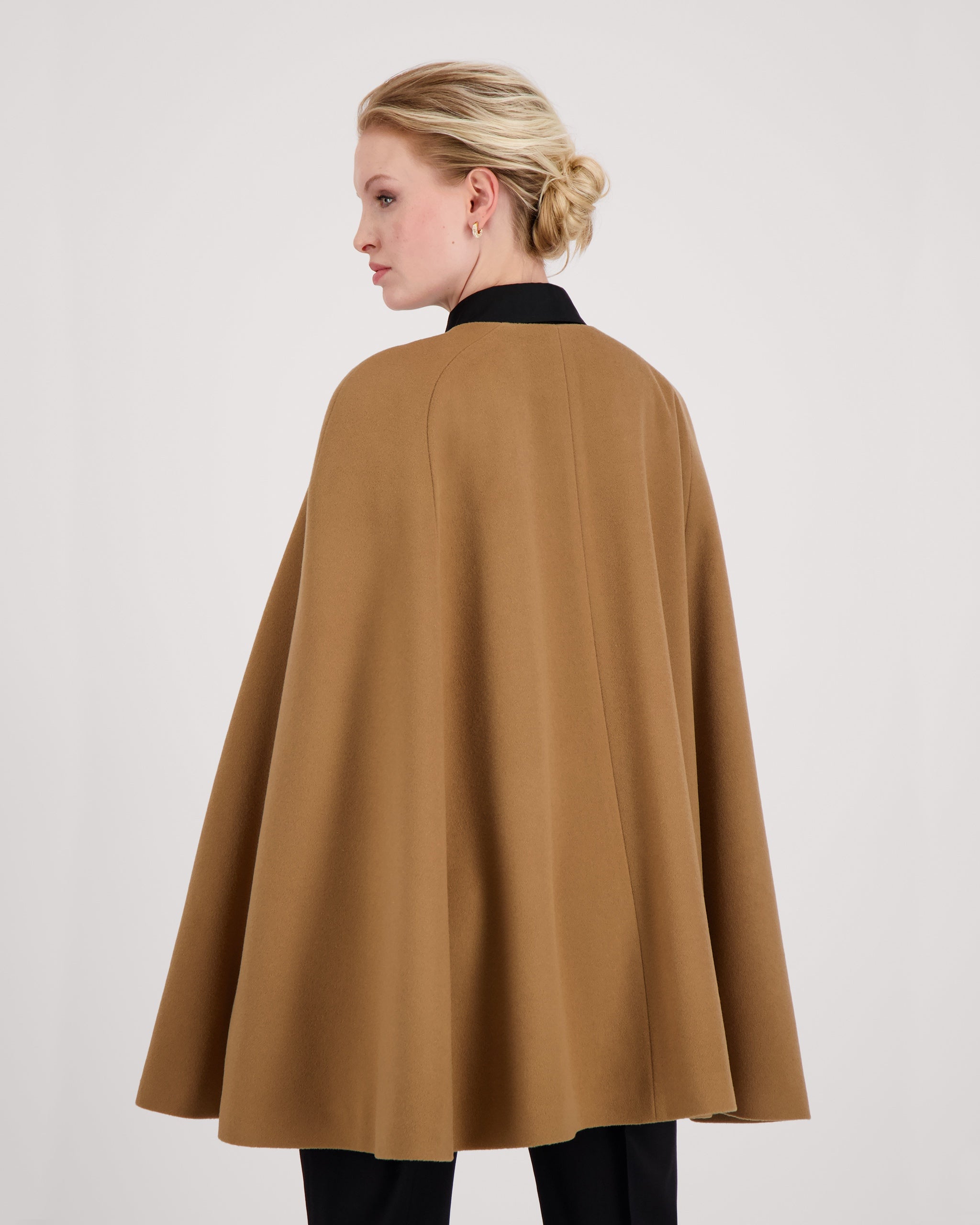 Cape-Mantel aus reinem Kaschmir mit sanft modellierenden Schulterabnähern und fein gearbeiteten Ärmelschlitzen mit zarter Absteppung. Der matte Vier-Knopf-Verschluss aus Corozo hält die Silhouette klar und puristisch. Dezente Eingriffschlitze und eine versteckte Innentasche verbinden Funktionalität mit eleganter, reduzierter Formensprache.