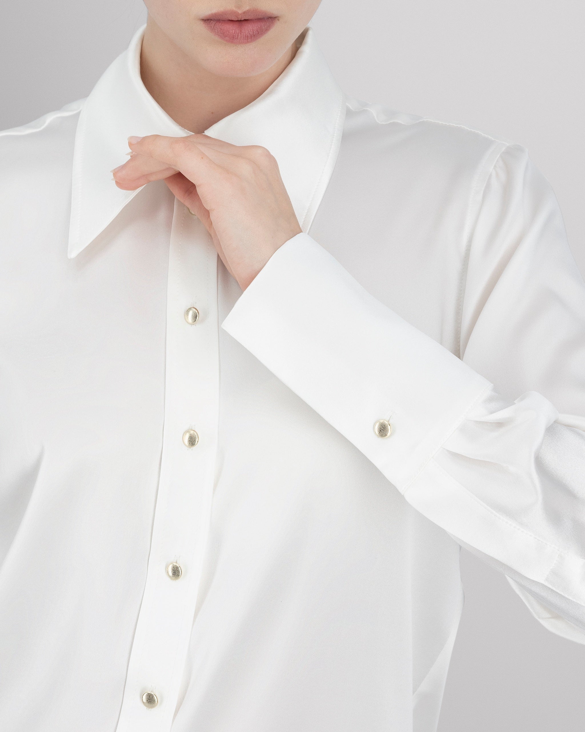 Bluse aus Peace Silk mit modernem, leicht vergrössertem Kragen und feiner Kantensteppung für einen ausdrucksstarken Look. Nach vorne versetzte Schulternähte, Rückenfalte und locker fallende Silhouette sorgen für entspannte Eleganz. Goldene Metallknöpfe, extralange Manschetten und ein fein abgesteppt Saum unterstreichen die präzise Verarbeitung.