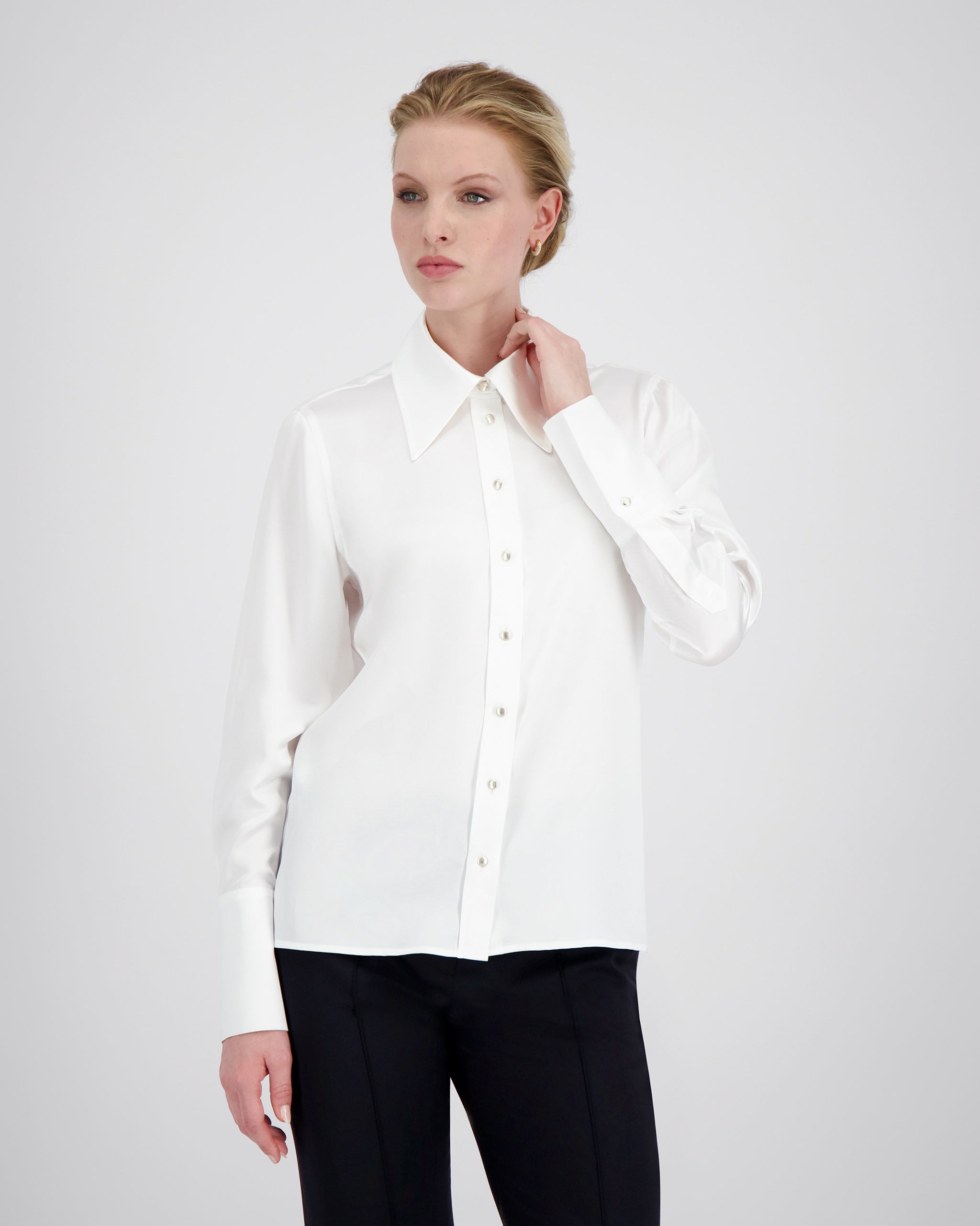 Bluse aus Peace Silk mit modernem, leicht vergrössertem Kragen und feiner Kantensteppung für einen ausdrucksstarken Look. Nach vorne versetzte Schulternähte, Rückenfalte und locker fallende Silhouette sorgen für entspannte Eleganz. Goldene Metallknöpfe, extralange Manschetten und ein fein abgesteppt Saum unterstreichen die präzise Verarbeitung.