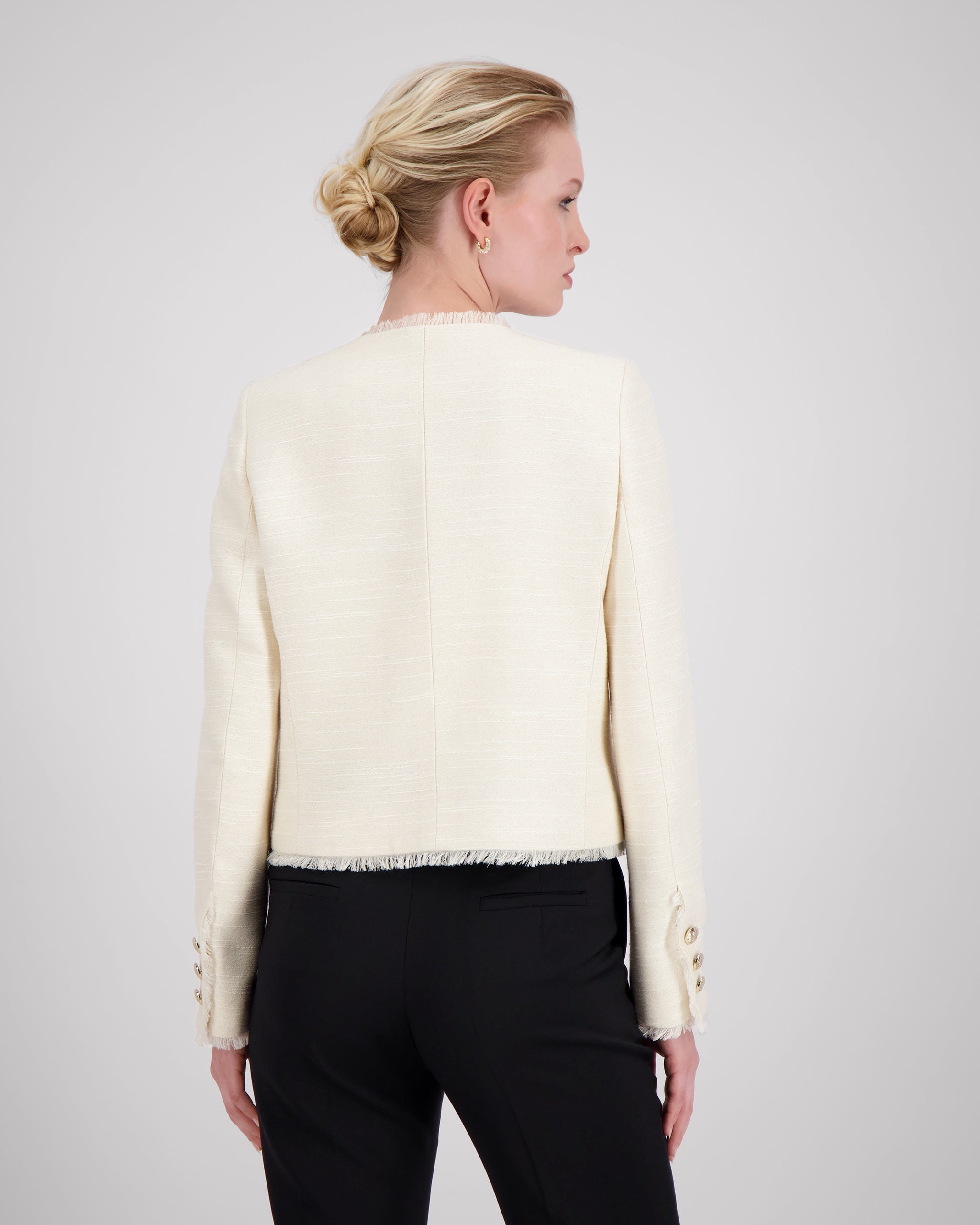 Jackett mit ausgefranstem Halsausschnitt und roher Frontkante für eine subtile, avantgardistische Note. Schulterpolster, Passformnähte und versetzte Seitennaht formen eine elegante Silhouette. Zweiteilige Ärmel, goldene Metallknöpfe und dezente Taschen stehen für präzise Handwerkskunst. Ausgefranster Saum und Ärmelschlitze setzen künstlerische Akzente.