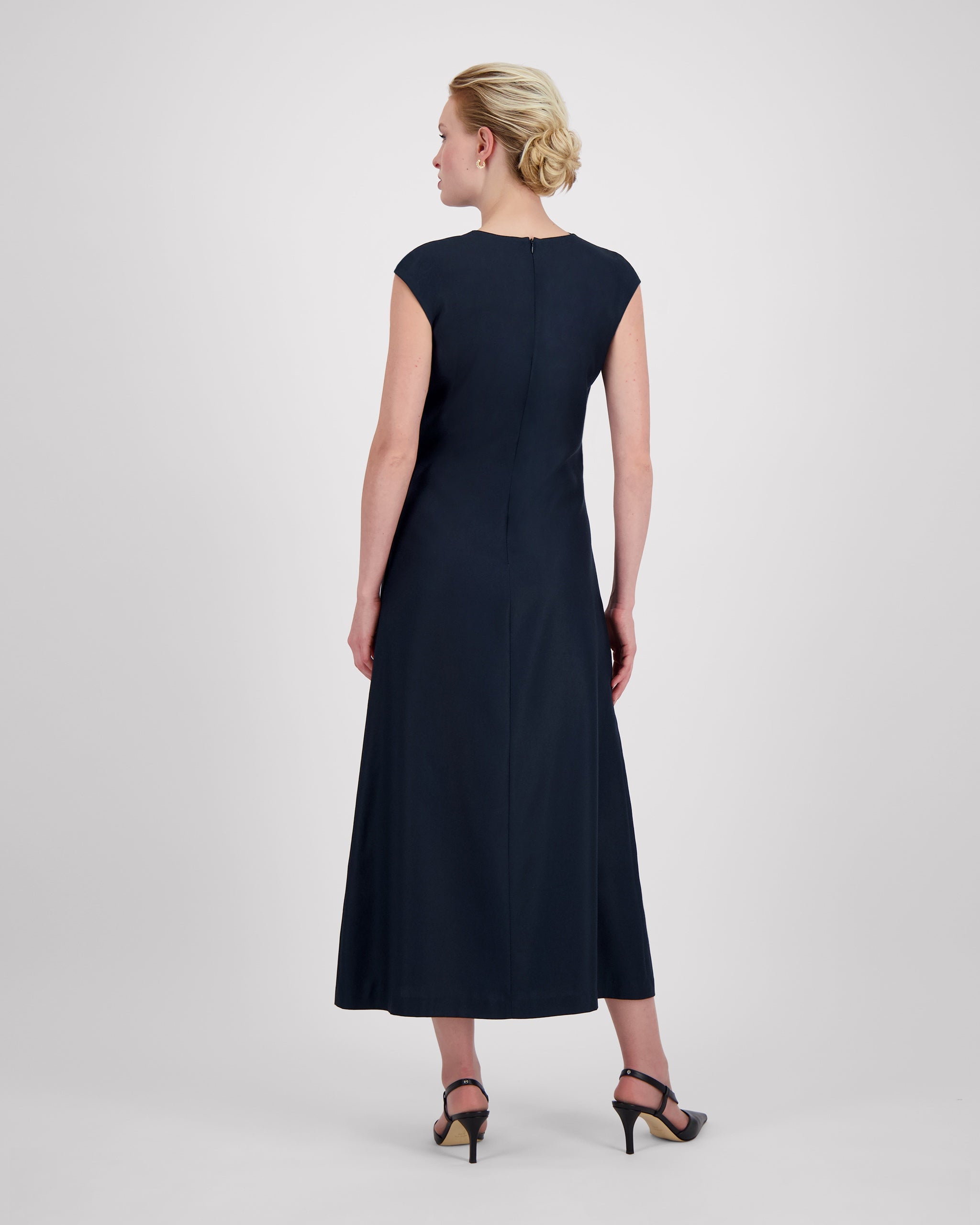 Kleid mit sanft drapiertem Halsausschnitt und nahtloser Verarbeitung für eine klare, elegante Halslinie. Lockere Passform mit formenden Abnähern vorn und weich fallendem, leicht ausgestelltem Rock für anmutige Bewegung. Nahtverdeckter Reissverschluss hinten und unsichtbarer Blindsaum sorgen für ein puristisches, präzise gefertigtes Finish.