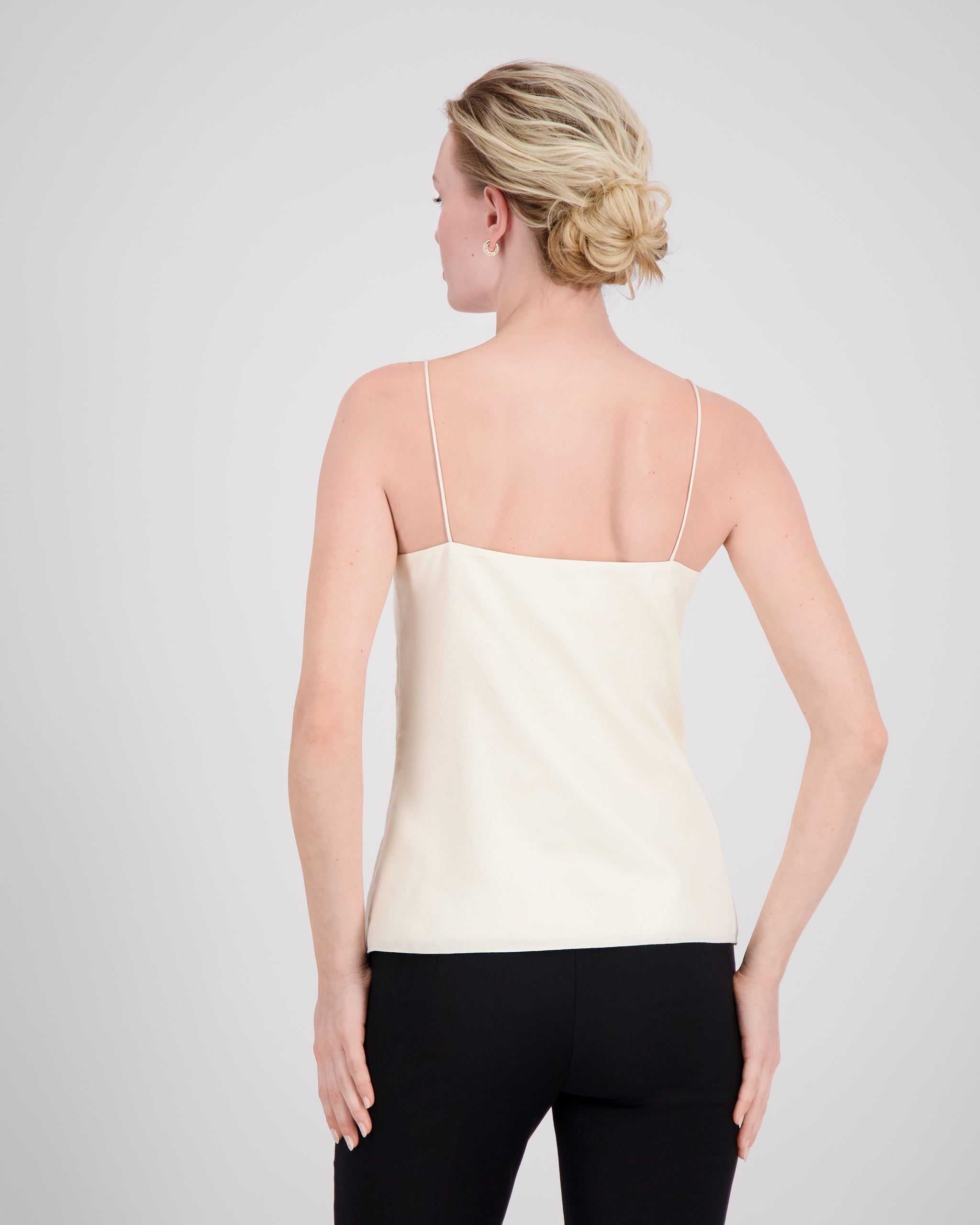 Zartes Top mit feinen, runden Trägern und dezentem V-Ausschnitt für eine klare, feminine Linie. Unsichtbare Nähte im Ausschnitt und sanfte Abnäher betonen die Silhouette mit eleganter Zurückhaltung. Der doppelt umgeschlagene Saum auf Hüfthöhe setzt einen feinen Akzent. Vollständig gefüttert für höchsten Tragekomfort und luxuriöses Finish.