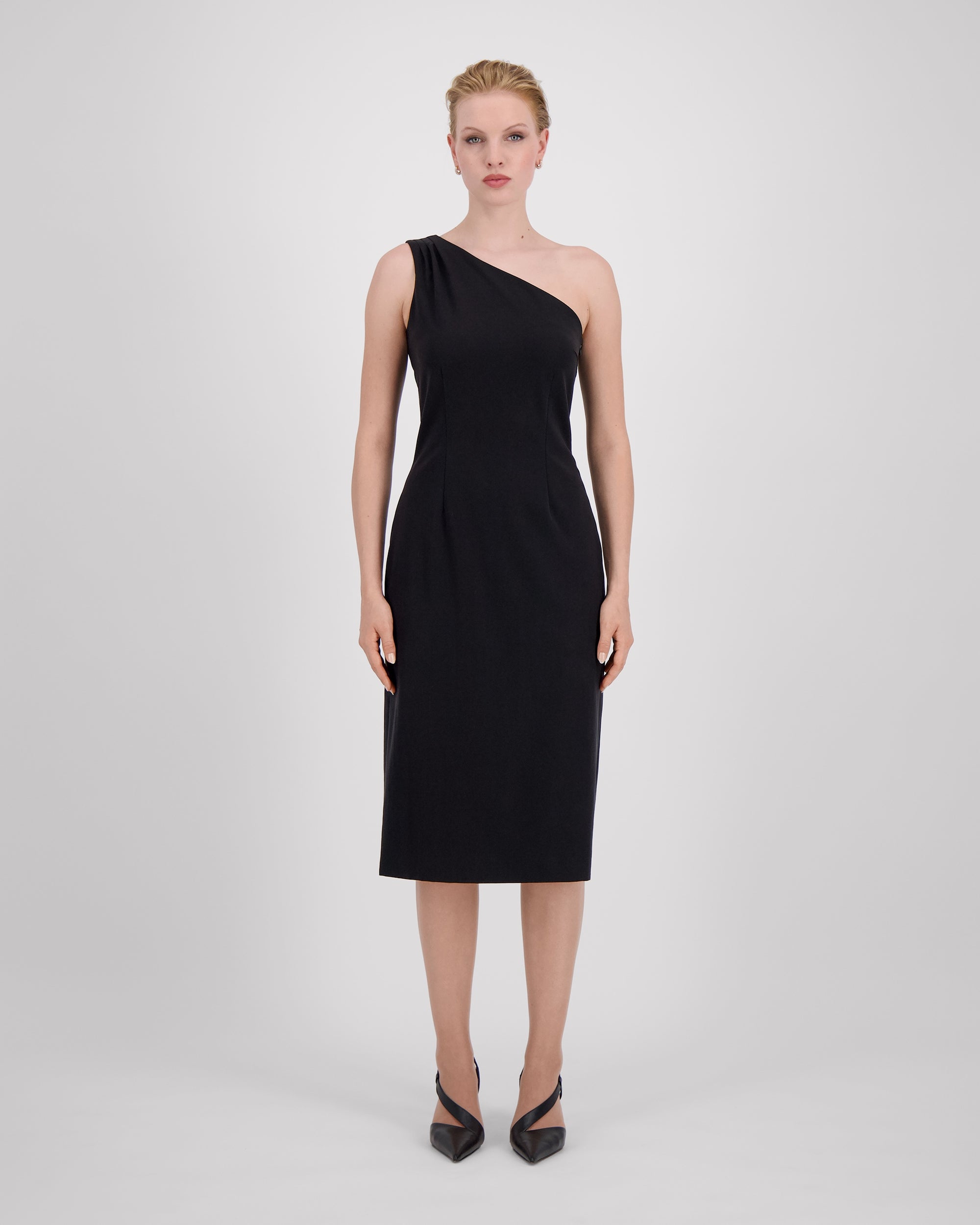 Asymmetrisches Kleid mit skulpturaler Schulterlinie und drei feinen Falten für eine fliessende Drapierung. Figurformende Abnäher vorn und hinten betonen eine elegante Silhouette. Unter dem Knie endend, mit rückwärtigem Gehschlitz für Bewegungsfreiheit. Nahtverdeckter Reissverschluss an der Seite und Blindsaum für ein puristisches Finish.
