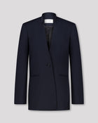 Blazer mit nach vorne versetzter Seitennaht und formgebenden Passformnähten für eine schlanke, konturierte Silhouette. Schulterpolster verleihen klare Struktur, zweiteilige Ärmel sorgen für präzisen Sitz. Dezente Details wie Ärmelschlitz, Corozo-Knopf, Rückenschlitz und schmale Pattentasche unterstreichen das reduzierte, fliessende Design.
