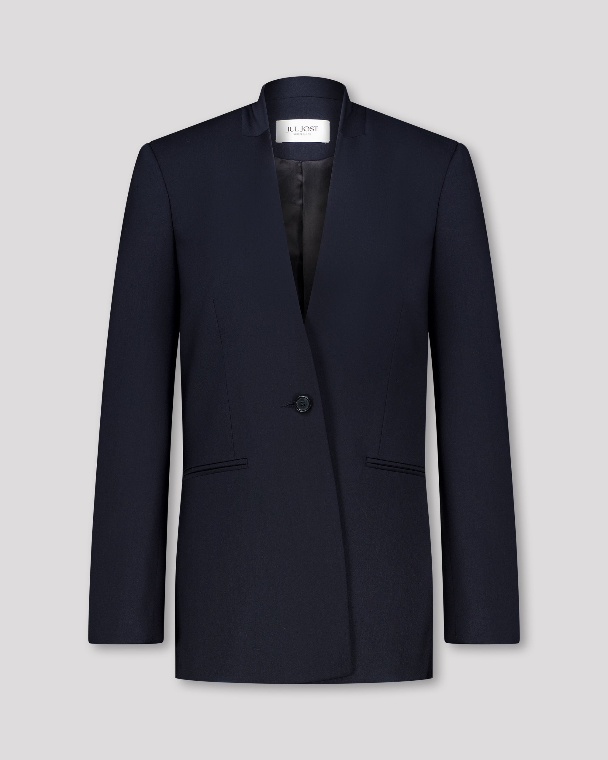 Blazer mit nach vorne versetzter Seitennaht und formgebenden Passformnähten für eine schlanke, konturierte Silhouette. Schulterpolster verleihen klare Struktur, zweiteilige Ärmel sorgen für präzisen Sitz. Dezente Details wie Ärmelschlitz, Corozo-Knopf, Rückenschlitz und schmale Pattentasche unterstreichen das reduzierte, fliessende Design.
