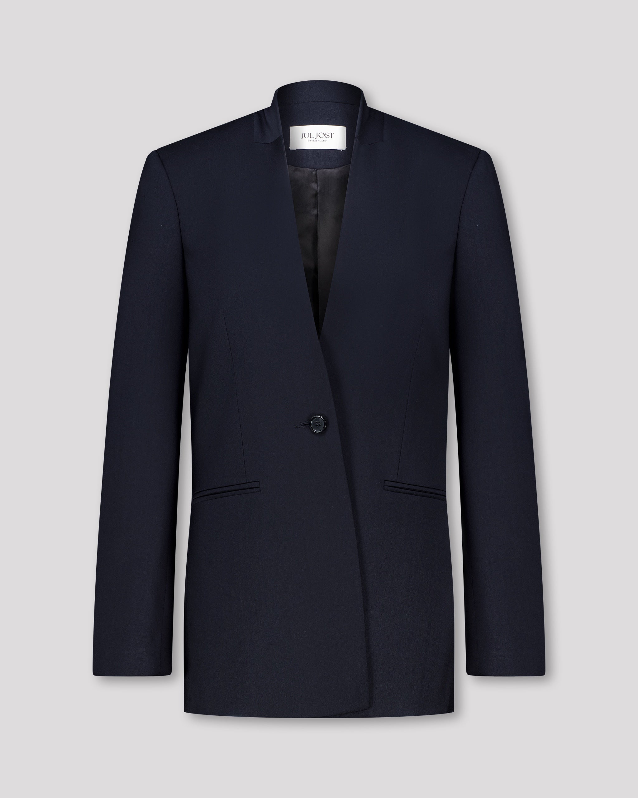 Blazer mit nach vorne versetzter Seitennaht und formgebenden Passformnähten für eine schlanke, konturierte Silhouette. Schulterpolster verleihen klare Struktur, zweiteilige Ärmel sorgen für präzisen Sitz. Dezente Details wie Ärmelschlitz, Corozo-Knopf, Rückenschlitz und schmale Pattentasche unterstreichen das reduzierte, fliessende Design.