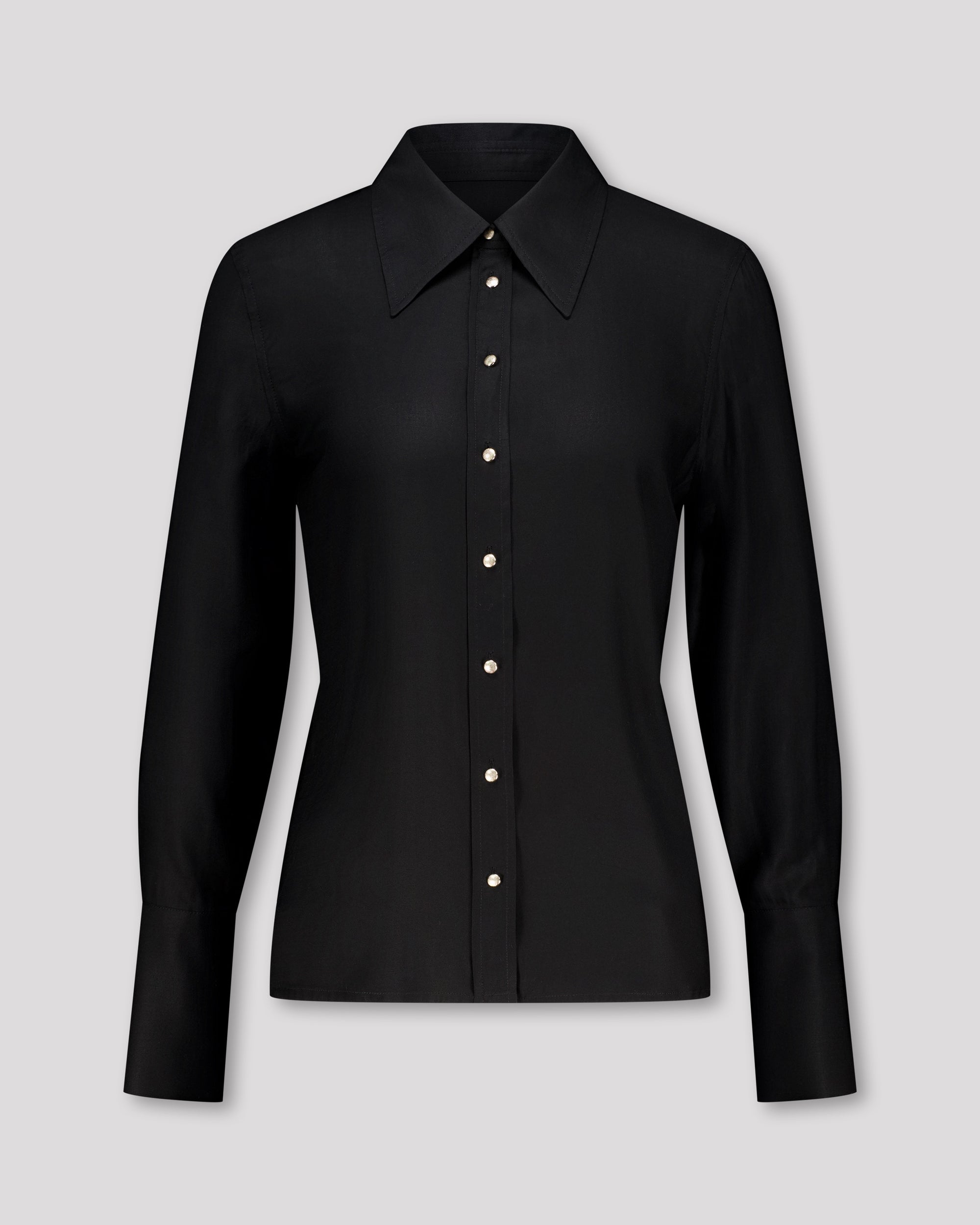 Elegante Bluse mit leicht vergrössertem Kragen und feiner Kantensteppung für ein markantes, selbstbewusstes Statement. Locker fallende Silhouette mit nach vorne versetzter Schulternaht und Rückenfalte für strukturierten, fliessenden Sitz. Durchgehende Knopfleiste mit Corozo-Knöpfen und extralangen Manschetten für präzise, detailreiche Verarbeitung.