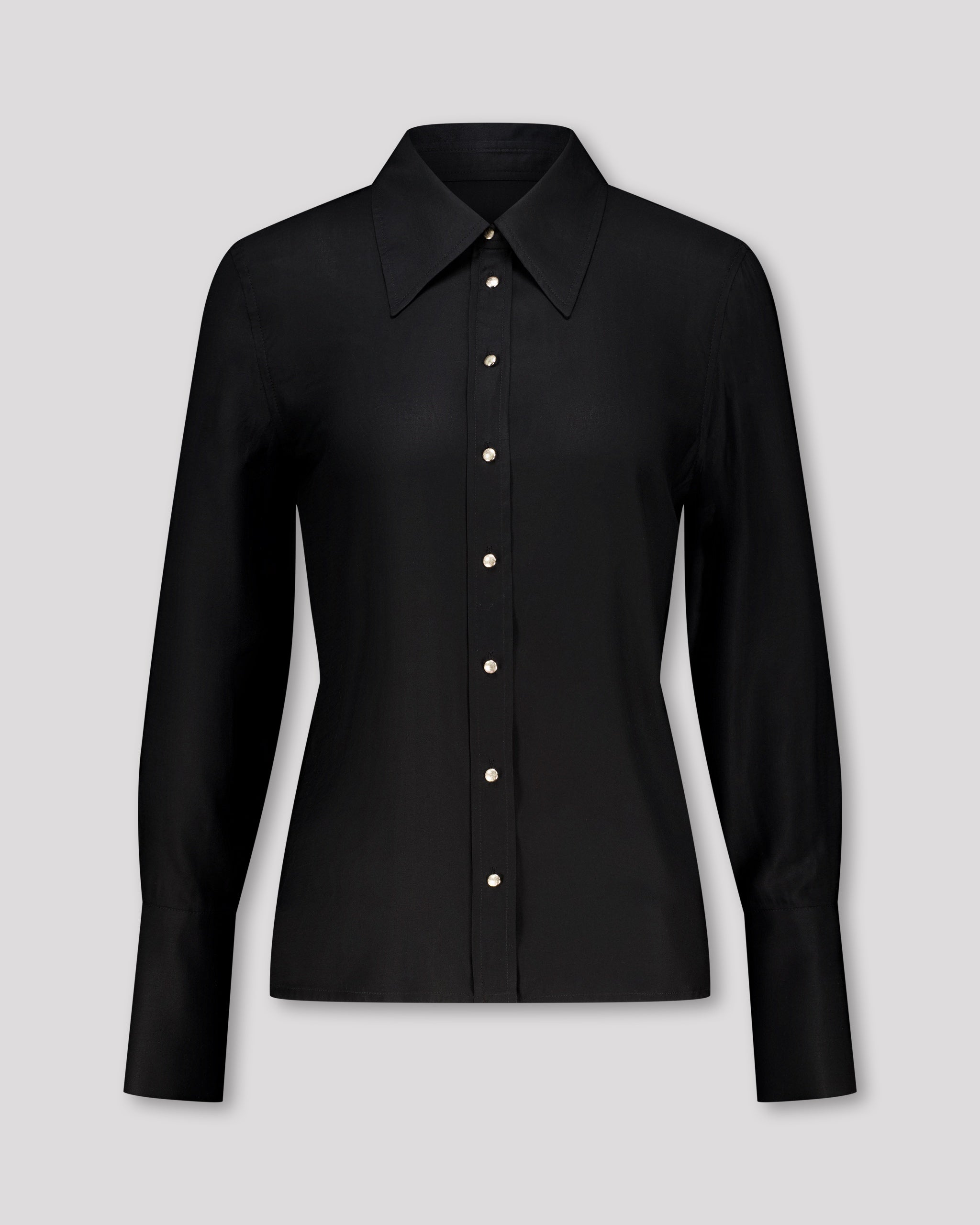 Elegante Bluse mit leicht vergrössertem Kragen und feiner Kantensteppung für ein markantes, selbstbewusstes Statement. Locker fallende Silhouette mit nach vorne versetzter Schulternaht und Rückenfalte für strukturierten, fliessenden Sitz. Durchgehende Knopfleiste mit Corozo-Knöpfen und extralangen Manschetten für präzise, detailreiche Verarbeitung.