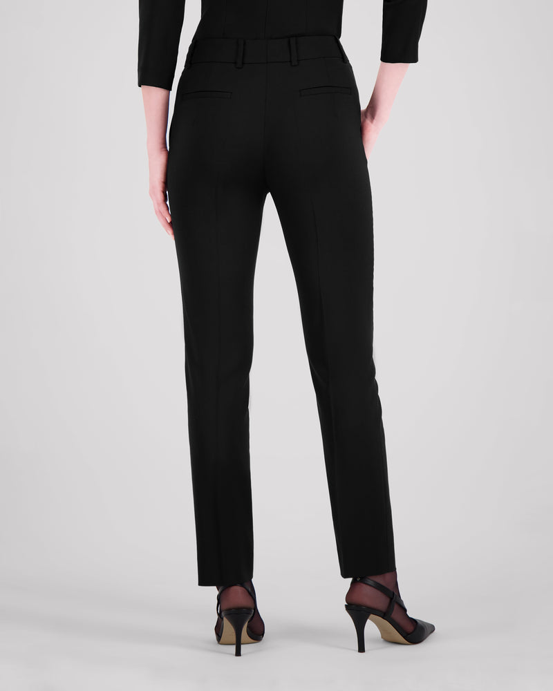 Knöchellange Hose mit schmalem Beinverlauf, unsichtbarem Saum und klarer Silhouette. Eine Mittelnaht vorn und eine Bügelfalte hinten strukturieren das Bein dezent. Seitliche Eingrifftaschen und rückwärtige Pattentaschen fügen sich nahtlos ins puristische Design ein. Verdeckter Bundverschluss mit Corozo-Knopf für eine makellose Front.
