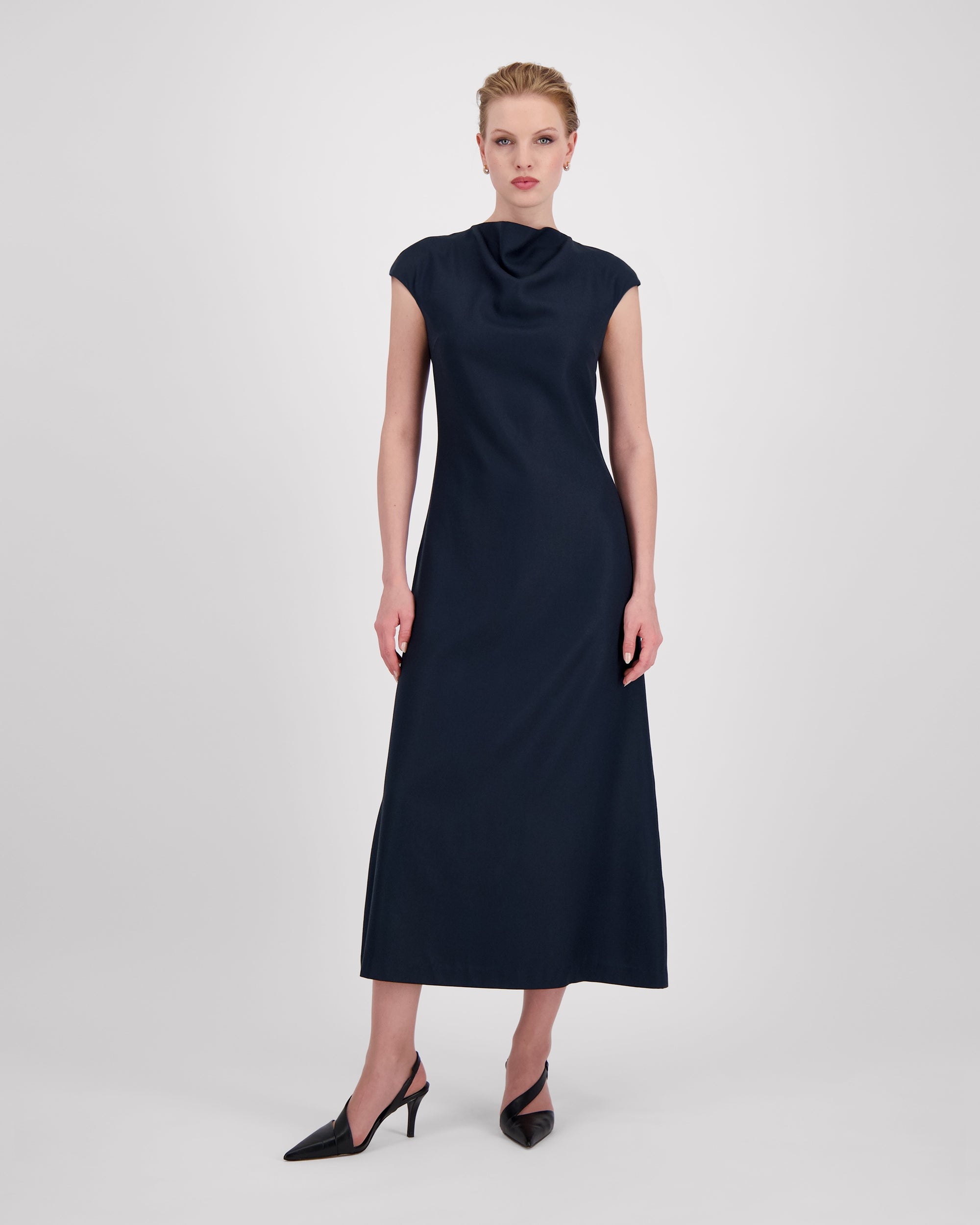 Kleid mit sanft drapiertem Halsausschnitt und nahtloser Verarbeitung für eine klare, elegante Halslinie. Lockere Passform mit formenden Abnähern vorn und weich fallendem, leicht ausgestelltem Rock für anmutige Bewegung. Nahtverdeckter Reissverschluss hinten und unsichtbarer Blindsaum sorgen für ein puristisches, präzise gefertigtes Finish.