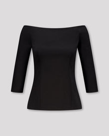 Top mit geradem Ausschnitt vorne und hinten, 3/4-Ärmeln und feinen Abnähern für eine strukturierte, feminine Silhouette. Der nahtverdeckte Reissverschluss im Rücken und der gerade Saum mit Blindsäumen unterstreichen die klare Linienführung. Fliessende Materialien und präzise Verarbeitung verleihen dem Design schlichte Eleganz und Leichtigkeit.