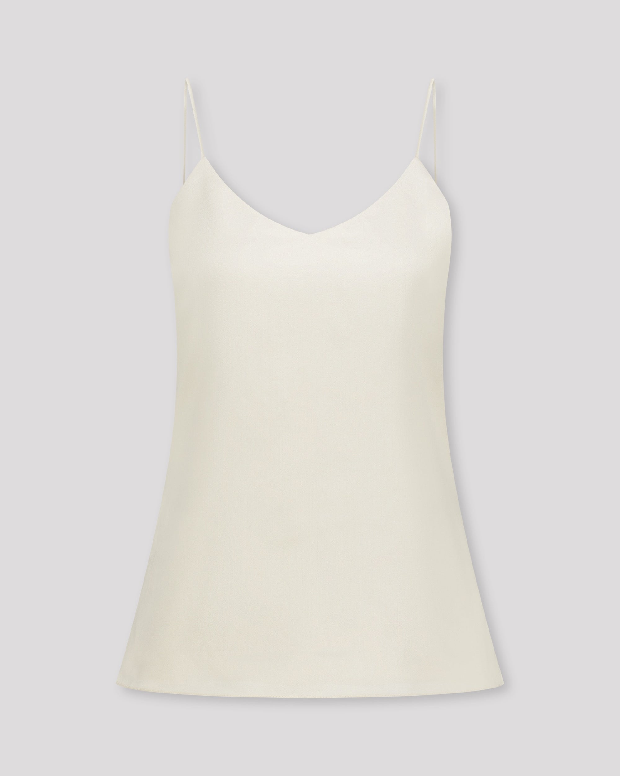 Zartes Top mit feinen, runden Trägern und dezentem V-Ausschnitt für eine klare, feminine Linie. Unsichtbare Nähte im Ausschnitt und sanfte Abnäher betonen die Silhouette mit eleganter Zurückhaltung. Der doppelt umgeschlagene Saum auf Hüfthöhe setzt einen feinen Akzent. Vollständig gefüttert für höchsten Tragekomfort und luxuriöses Finish.