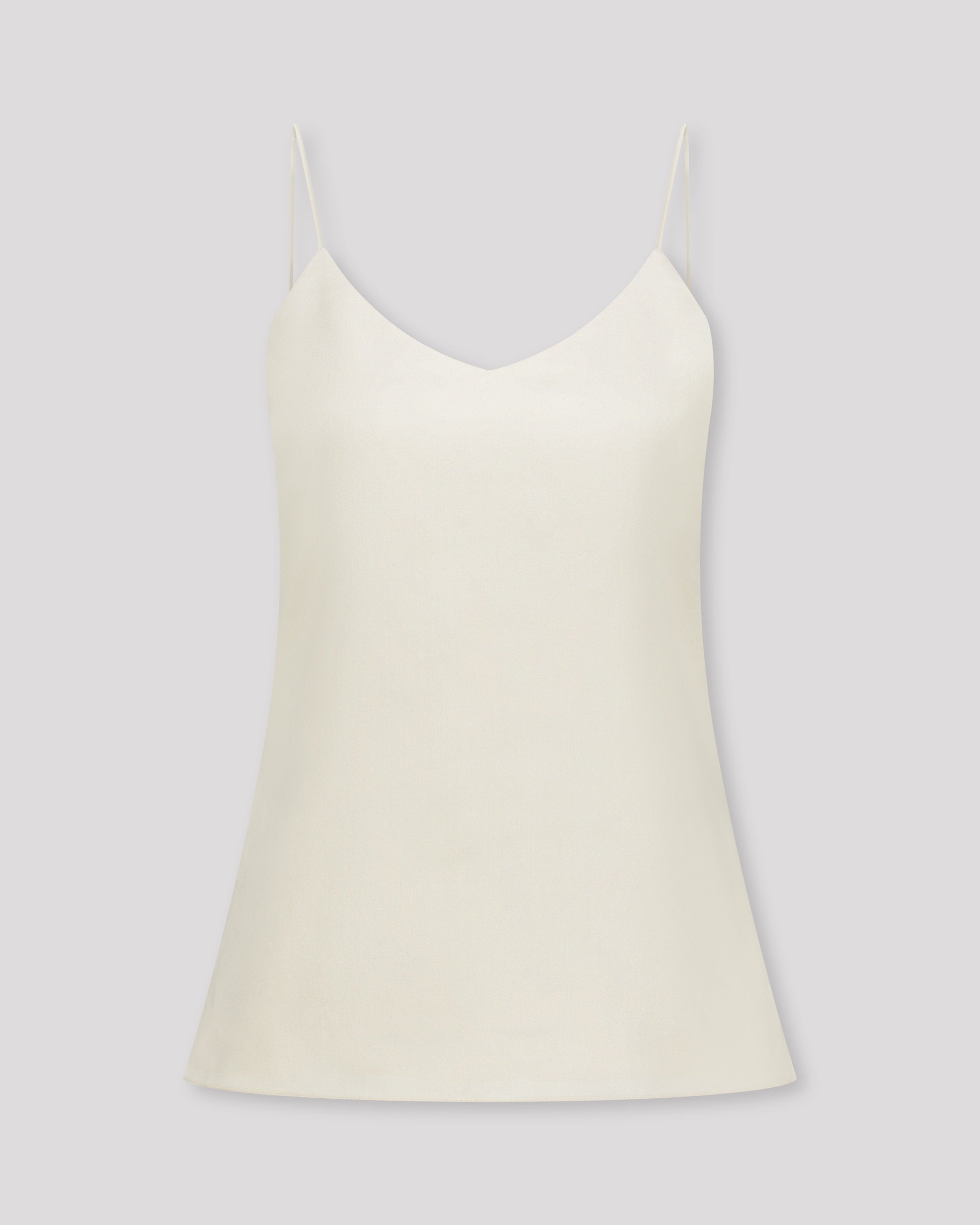 Zartes Top mit feinen, runden Trägern und dezentem V-Ausschnitt für eine klare, feminine Linie. Unsichtbare Nähte im Ausschnitt und sanfte Abnäher betonen die Silhouette mit eleganter Zurückhaltung. Der doppelt umgeschlagene Saum auf Hüfthöhe setzt einen feinen Akzent. Vollständig gefüttert für höchsten Tragekomfort und luxuriöses Finish.